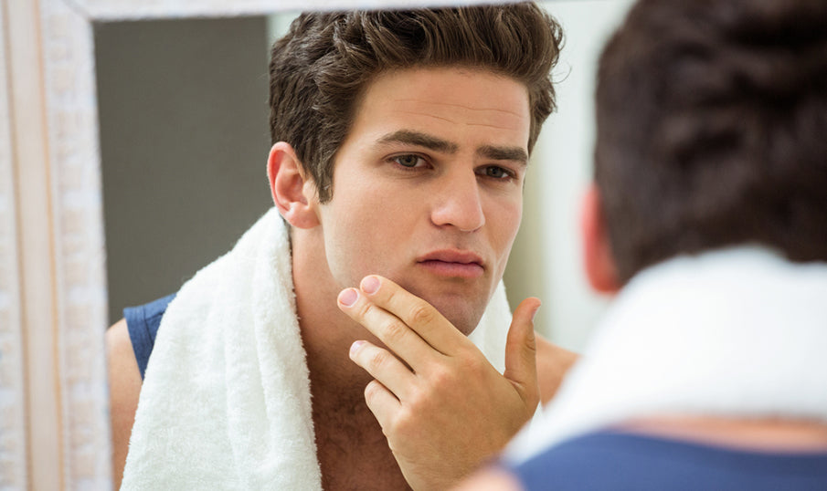 man in mirror looking at face