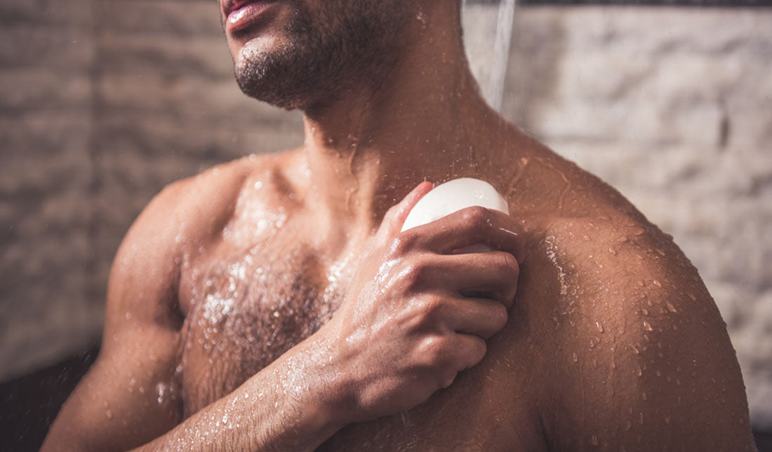 man rubbing chest with bar of soap