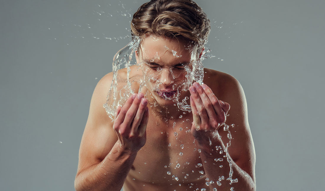 man splashing water onto face