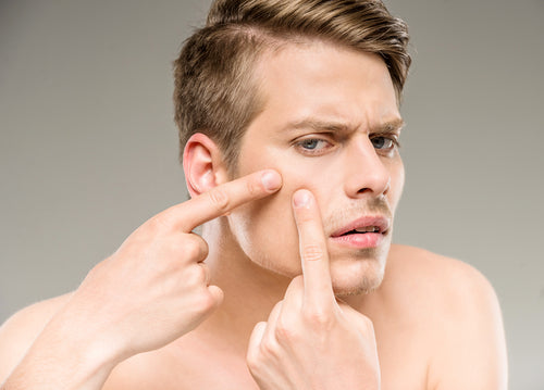 man squeezing blemish