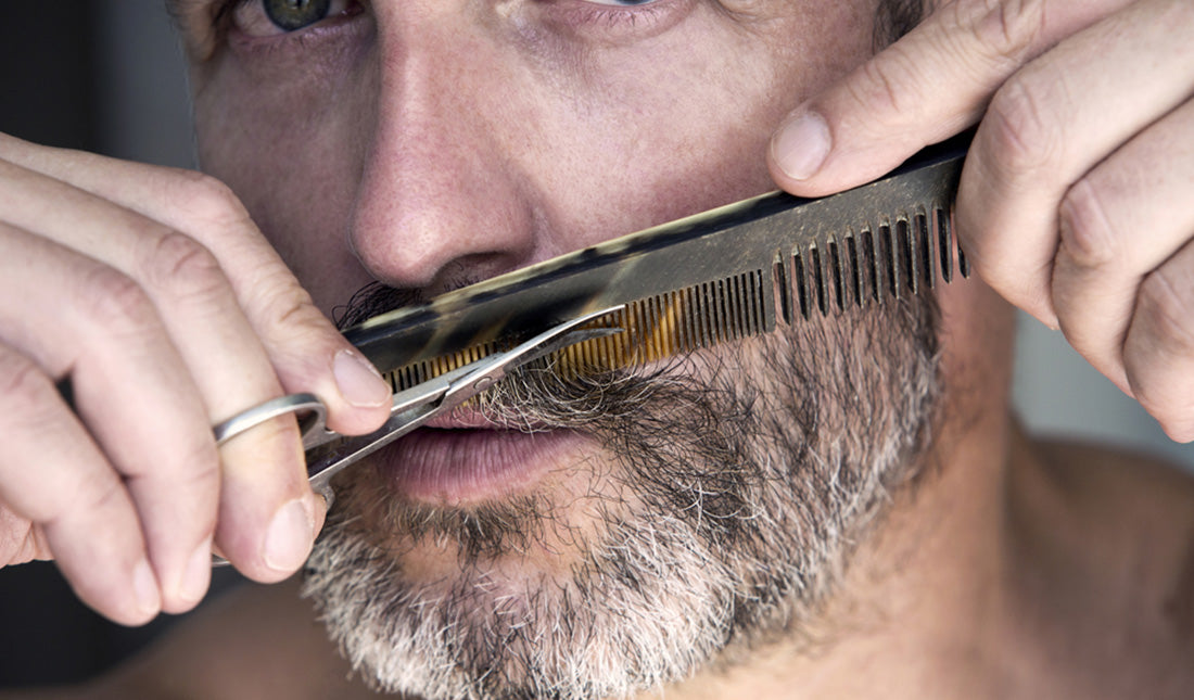 man trimming his beard