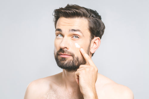 man pointing to eye cream