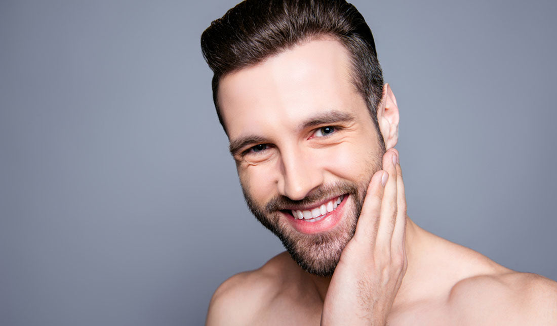 Atraktivan bradati muškarac dodiruje lice