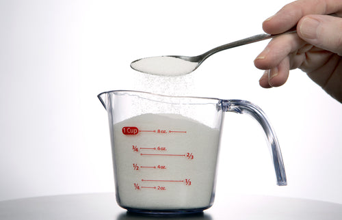 pouring sugar into measuring glass