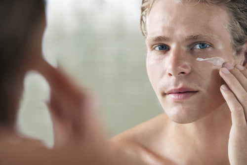 reflection of man using facial cream