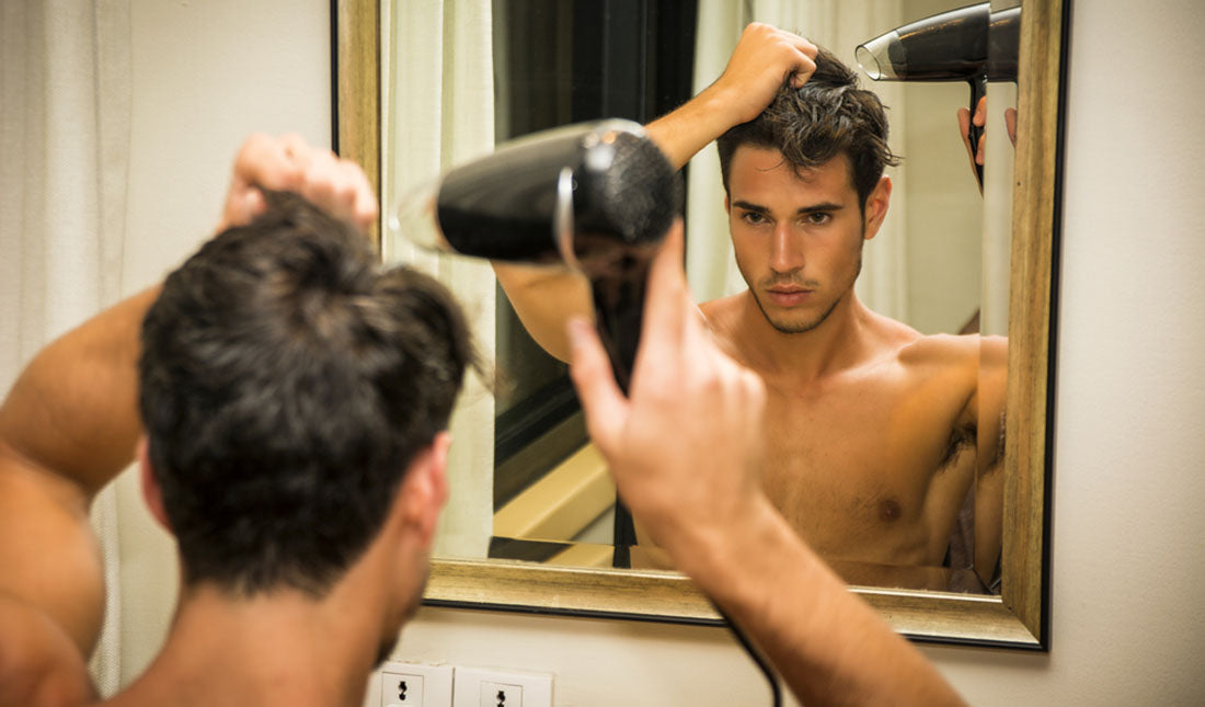 shirtless man drying hair