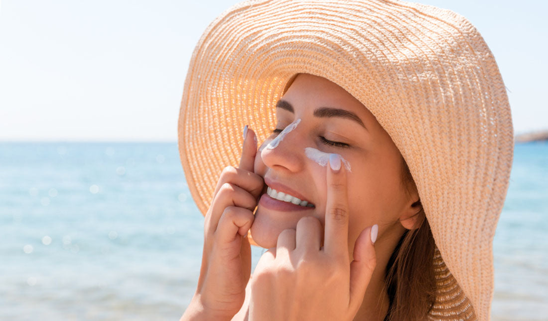 woman applying sunscreen under eyes