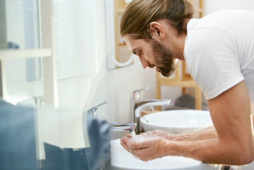 man washing his face