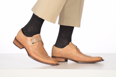 Sophisticated black Hugh Ugoli socks with subtle pattern, complementing tan monk-strap shoes and khaki trousers.