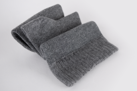 A neatly folded pair of grey Hugh Ugoli socks against a clean white background, showcasing the fine texture and quality.