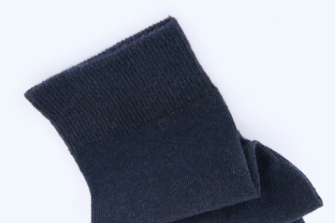 A folded pair of dark navy socks against a white background, showcasing a close-up of the fabric's texture.