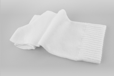 A pair of white socks is laid flat, showcasing their simple design and texture.