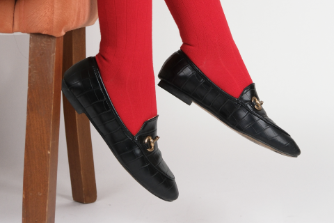 Red socks paired with black loafers, a bold fashion choice.