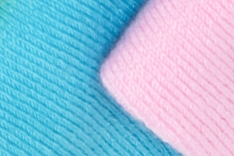 Detail of Hugh Ugoli socks, showcasing the fine weave in vibrant pink and blue, exemplifying quality textile craftsmanship.