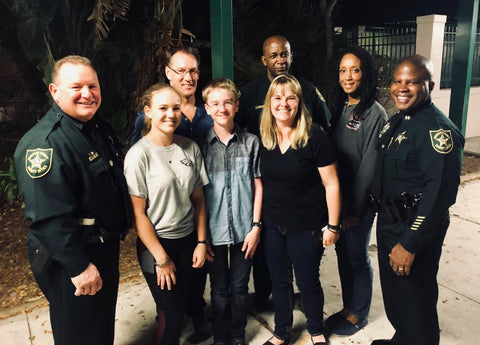 Sally Mitchell (in black tee) with her kids, police officers and Marjory Stoneman Douglas High School officials.