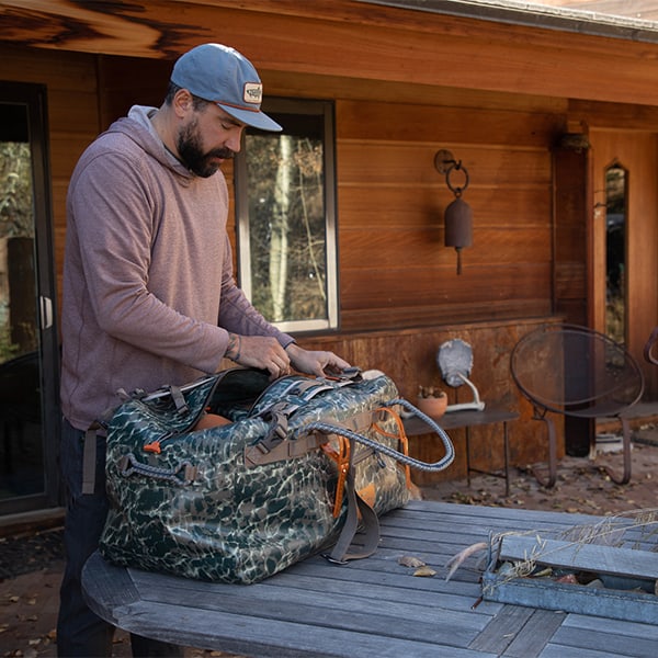 TLSD-ERC 816332015137 Fishpond Thunderhead Large Submersible And Waterproof Duffel Bag Newstream Model 2022 Eco Riverbed Camo On The Table