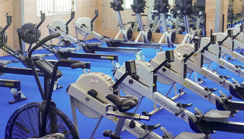 Close-up of indoor rowers and exercise bikes used in school gyms