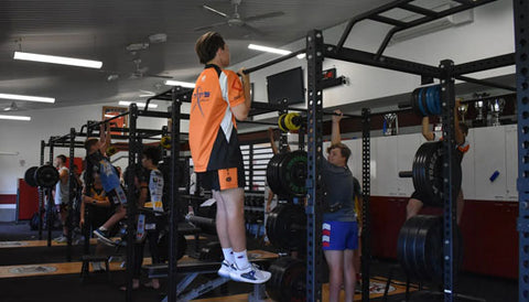 High school students engaged in strength training exercises.