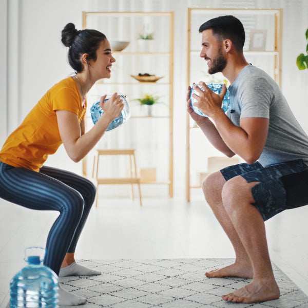 Couple squatting while working out indoors