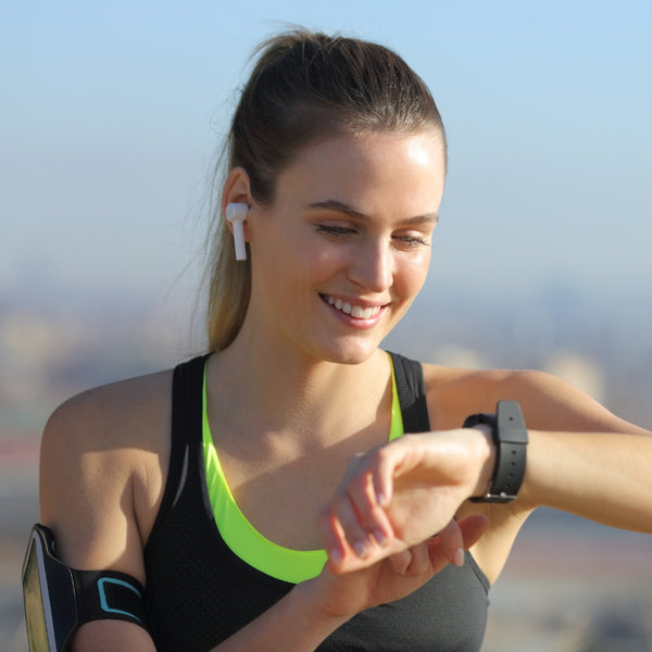 Woman about to start running looking at her smart watch