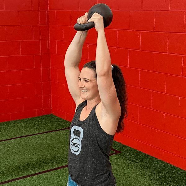 Woman doing an overhead Kettlebell press