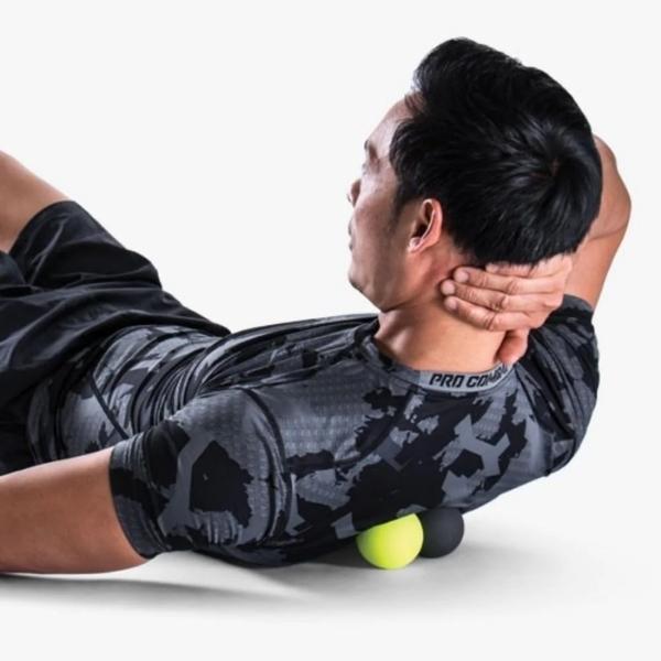 Man rolling Massage Balls on his Back