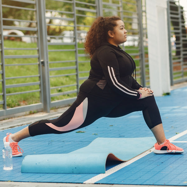 Woman doing a backwards lunge on outdoor tennis court