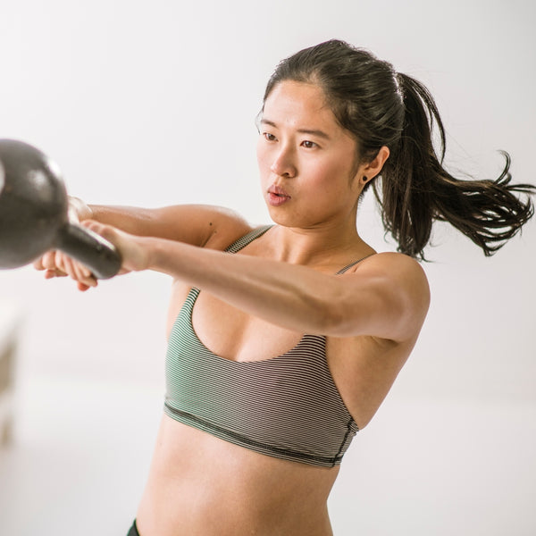 Woman lifting kettlebell with arms extended
