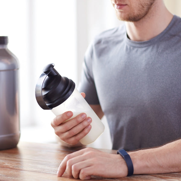 Man looking at supplement shaker bottle
