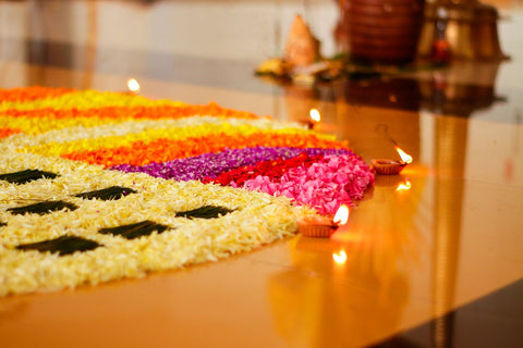 Onam festival celebration with lighting diyas and flowers