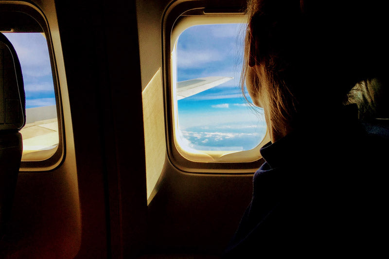 Girl looking outside an airplane window