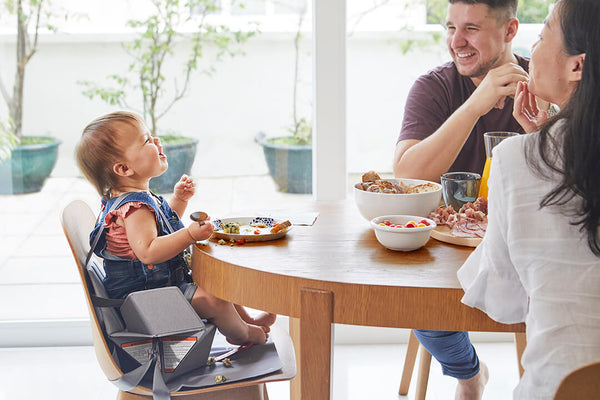 Baby on Pop Up booster at table with parents