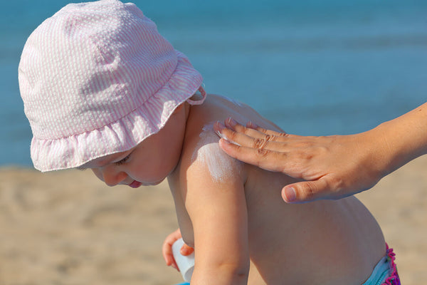 Baby with sunblock on shoulder