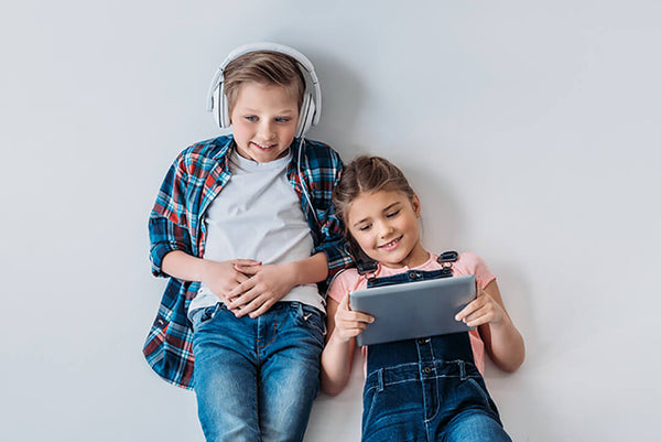 Two happy kids with headphone and device