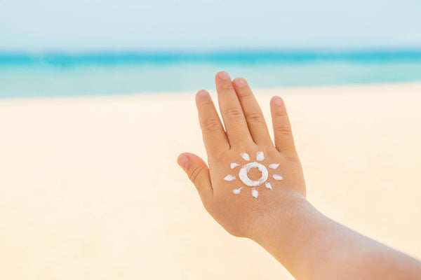 Child's hand with sun screen at the beach