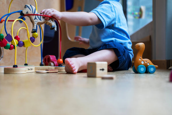 Boy plays with toys on the floor