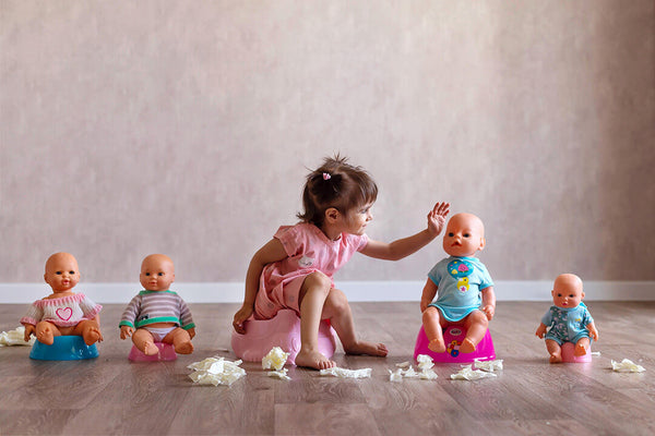 Girl on potty with dolls