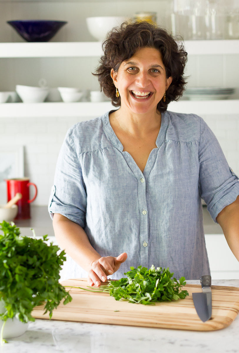 Paula chopping cilantro on kitchen table