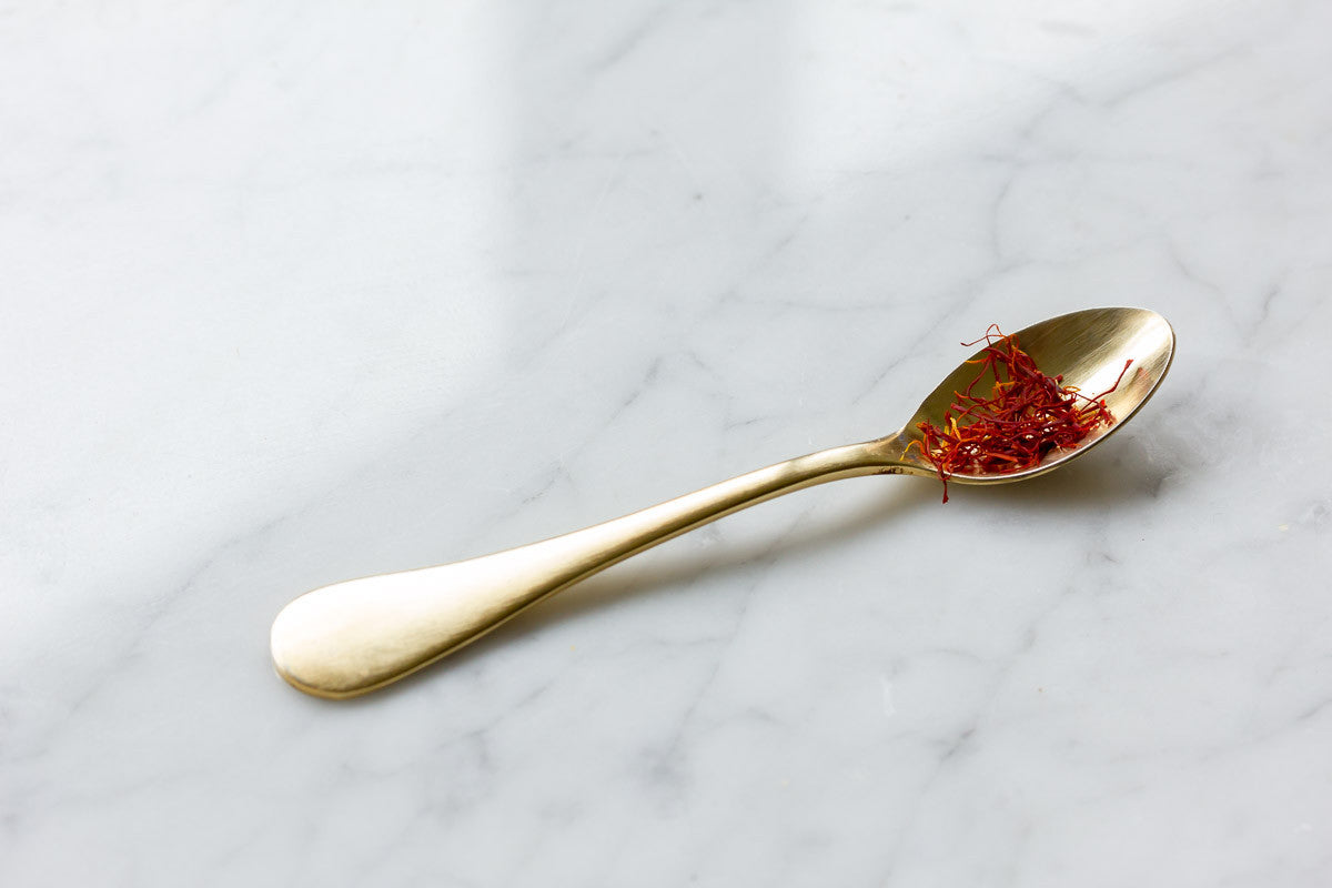 Gold teaspoon with spice on kitchen table