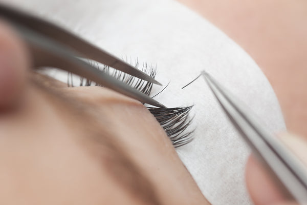 A lash tech applying a client’s lash extensions