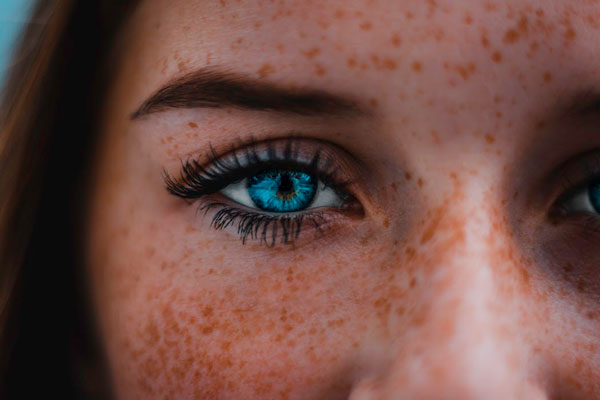 woman with blue eyes and strip eyelash extensions