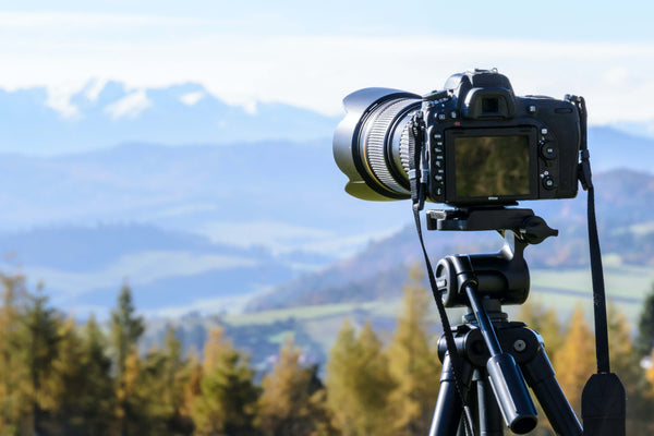 a camera on a tripod with a view of mountains