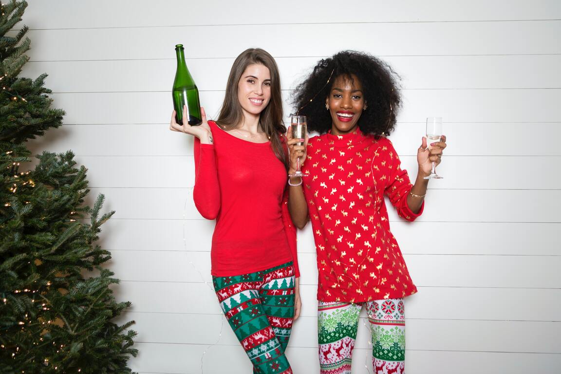 Two friends wearing red and green holiday outfits