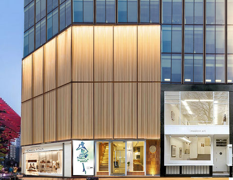 A fashion mall building is lighted up by wall washing lights.