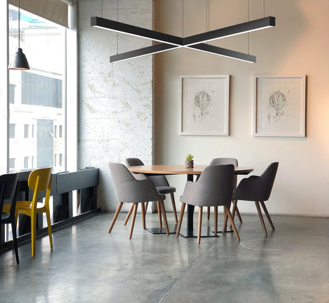 Cross-shaped LED linear lights suspended from ceiling of a dining area to illuminate the space