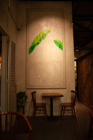 A wall with artistic drawings is highlighted by accent lighting in a restaurant.