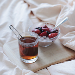 a bowl of berries and a cup of tea