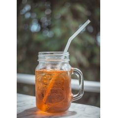 mason jar full of sweet tea and a straw