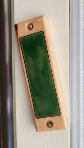 A simple wood and epoxy mezuzah adorn a doorway