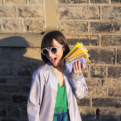 model holding group of bright zip purses